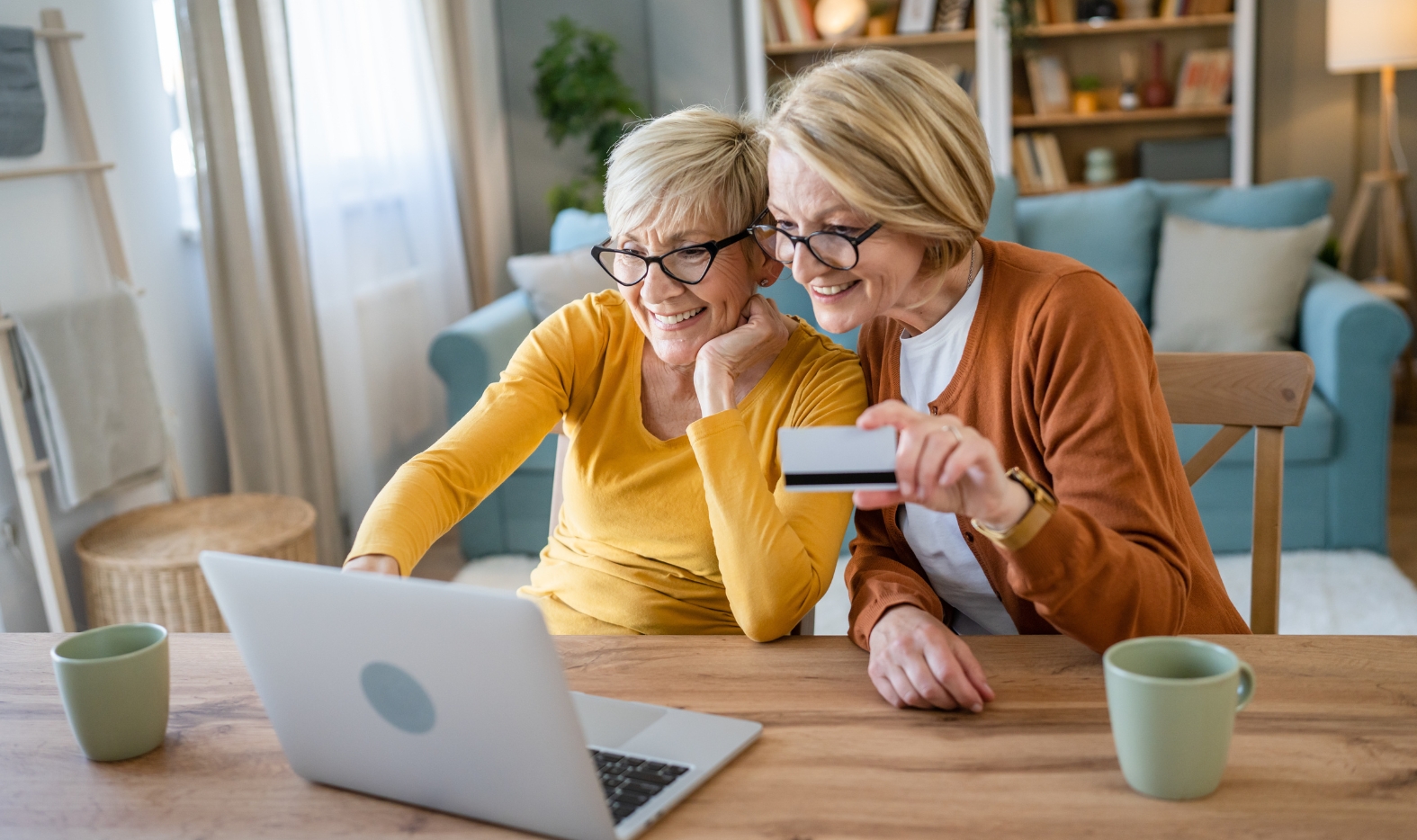 two adults looking at a computer holding a credit card